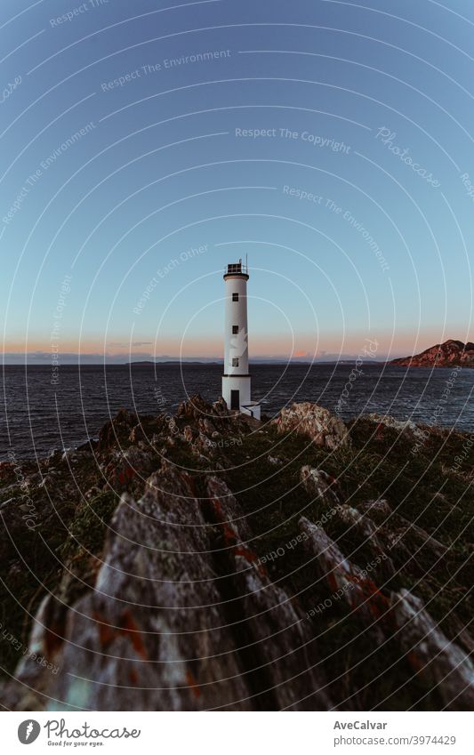Ein Leuchtturm an der spanischen Küste während der Hexenstunde im Weitwinkel mit Kopierraum Vorstellungskraft Hilfsbereitschaft Inspiration Hintergründe