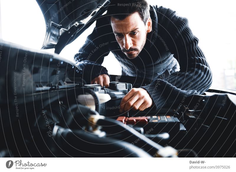 Mann untersucht sein Auto Motorhaube prüfen defekt PKW kontrollieren reparieren kaputt Fahrzeug Kontrolle verärgert sauer