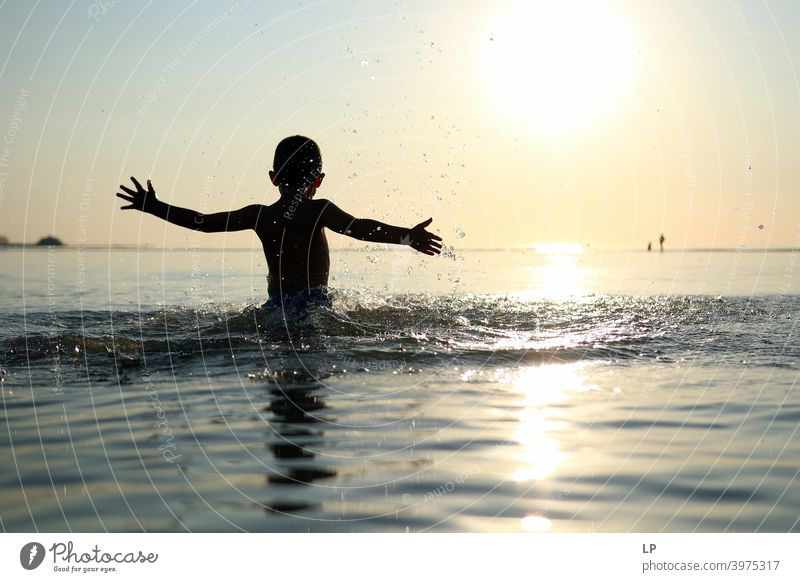 glückliches Kind im Ozean bei Sonnenuntergang Tanzen Glaube und Religion Hintergrund weitergeben Arme Hand Zufriedenheit Körperhaltung Ferien & Urlaub & Reisen