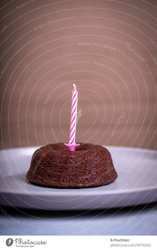 Kleiner Schokoladekuchen mit einer Geburtstagskerze Kuchen einzeln Feste & Feiern Geburtstagstorte lecker Innenaufnahme süß Backwaren Kerze Teller pink