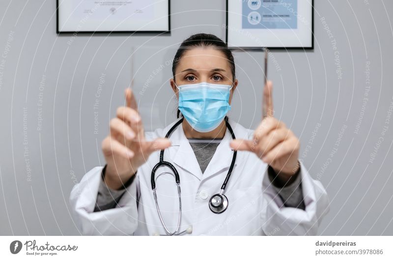 Weiblicher Arzt hält eine transparente Tablette futuristisch zeigend Frau covid-19 Technik & Technologie Glas Bildschirm Menschen weißer Kittel Gesundheitswesen