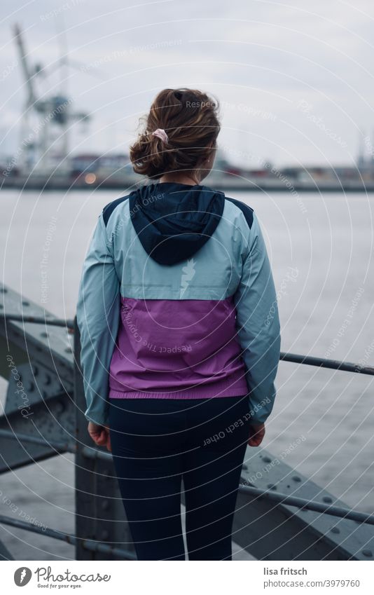 schöne Aussicht Hafen Hafenstadt Hamburg Wasser Rückenansicht trainingsjacke kalt Frau Locken Zopf Außenaufnahme Elbe warten Farbfoto