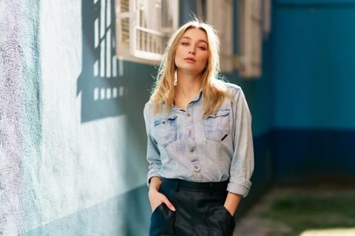 Blonde Frau in Jeanshemd und schwarzem Lederrock steht auf der Straße. Mädchen blond Russisch blau Auge Porträt Mode im Freien Dame Frisur Person weiß hübsch