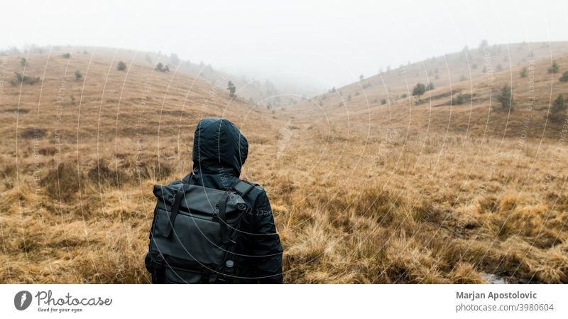 Junger Mann erkundet die Natur an einem nassen Wintermorgen in den Bergen Abenteuer allein Herbst schön Herausforderung kalt Europa Erkundung erkunden Entdecker