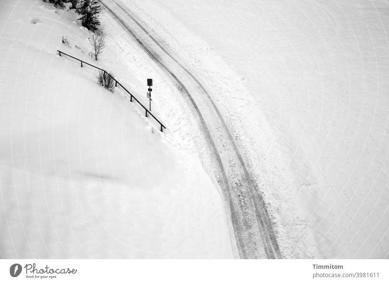 Wege und Pfade im Schnee Winter kalt gefroren Wege & Pfade Geländer Natur Fußspuren Fahrzeugspuren Schneedecke Gebüsch Hinweisschild Schwarzweißfoto