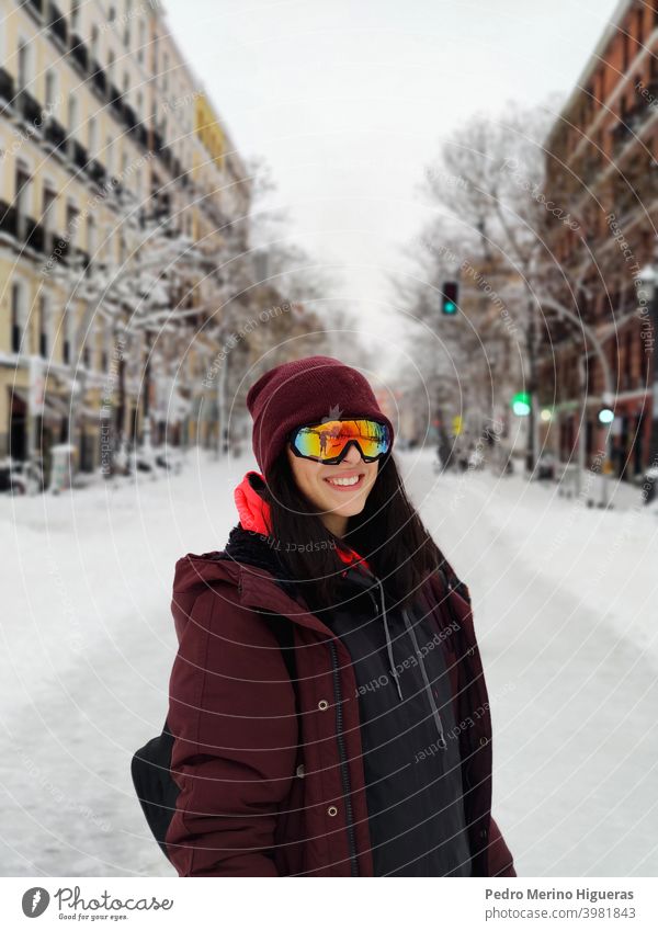 Frau mit Skibrille in der Mitte einer verschneiten Straße in Madrid Schnee Freiheit jung blau Lifestyle Sonnenbrille Spiegel Person Erholung Mundschutz Winter