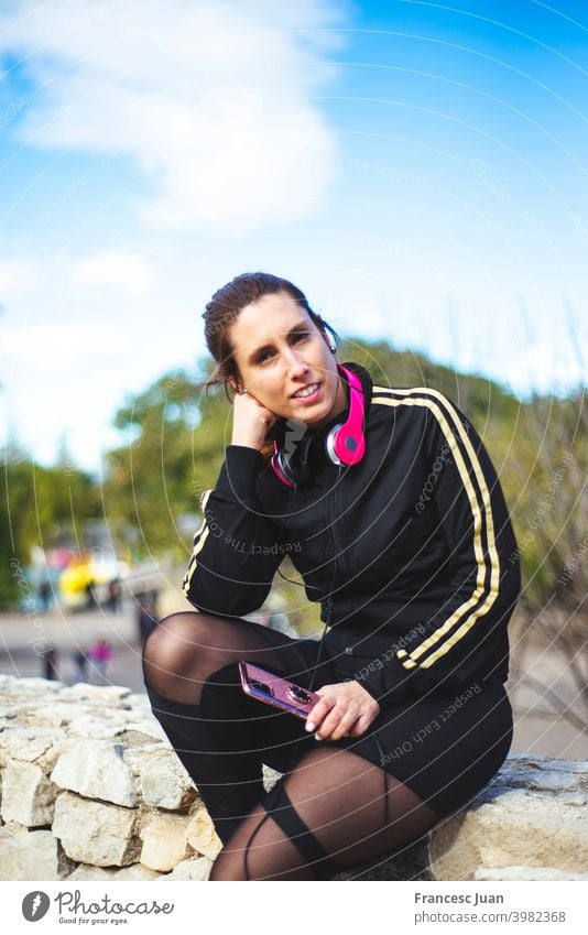 Porträt einer sportlichen jungen Frau mit Kopfhörern, während sie im Freien trainiert. heiter Musik Menschen Sport Erwachsener attraktiv Hintergrund schön blond