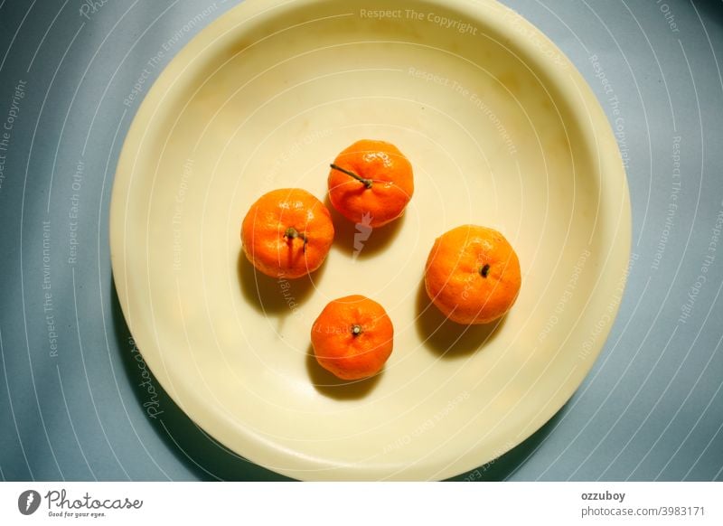orangefarbene Früchte auf gelbem Teller Vitamin frisch Frucht reif geschmackvoll Zitrusfrüchte Farbe Frische tropisch Hintergrund Diät Lebensmittel natürlich