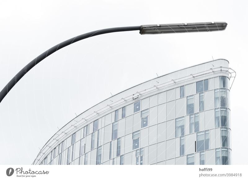 Bogenlampe und Aussenfassade bilden eine Einheit in kurvige Ausprägung Straßenbeleuchtung Fassade geboben Moderne Architektur Architekturfotografie ästhetisch