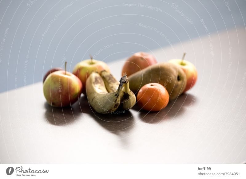 Früchte auf dem Tisch im Büro Frucht Banane Apfel Mandarin Birne Ernährung Lebensmittel Vegetarische Ernährung Bioprodukte Gesundheit lecker frisch Menschenleer