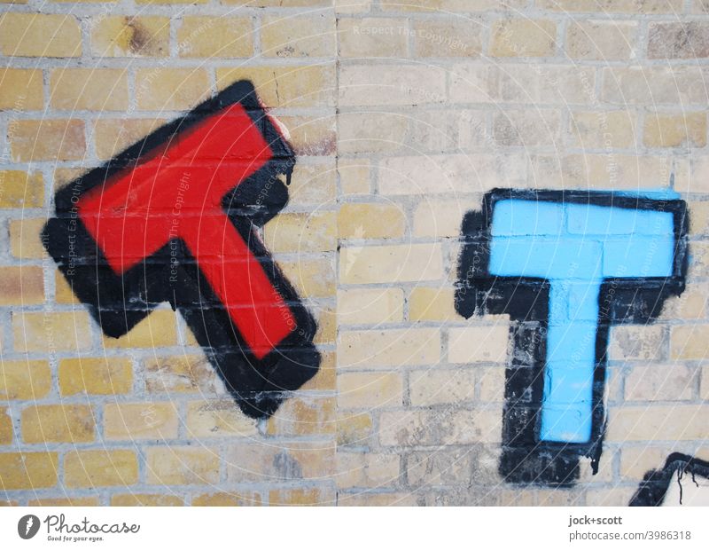 roter und blauer Buchstabe T aufgesprüht auf eine Mauer Backsteinmauer Straßenkunst Großbuchstabe Spray Kreativität umrandet Subkultur schwarzer Rand Berlin