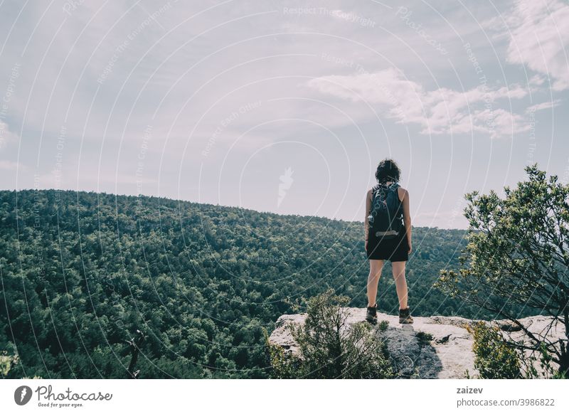 Mädchen, das wandern gegangen ist und die Landschaft auf einem Hügel an einem Sommertag betrachtet la febró prades Katalonien Spanien im Freien mittelgroß