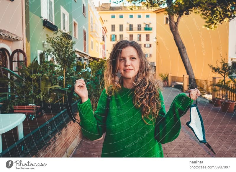 Junge Frau trägt grünen Oversize-Pullover und genießt einen windigen Tag in einer bunten Stadt reisen Porträt Lifestyle Model Europa Europäer blond im Freien