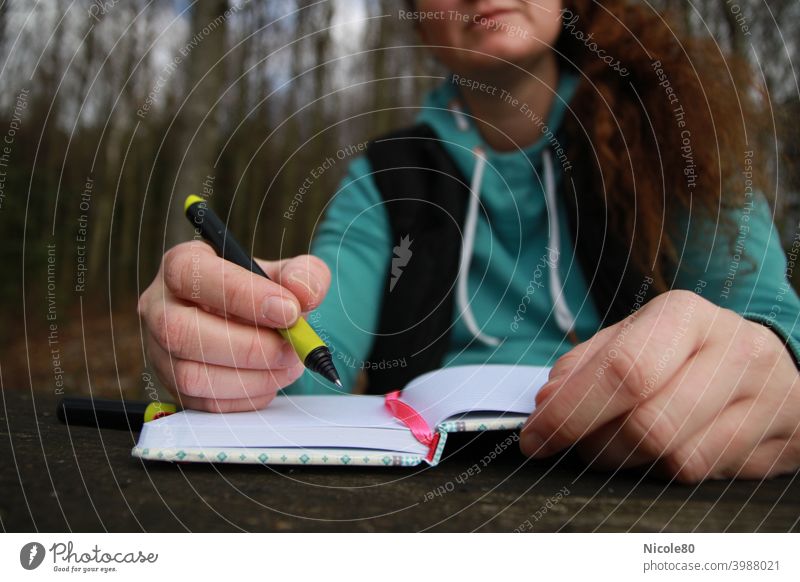 Schreibende Frau in der Natur schreiben schreibend Notizbuch Hände Wald Inspiration Holztisch hoodie Pullover denkend Tagebuch