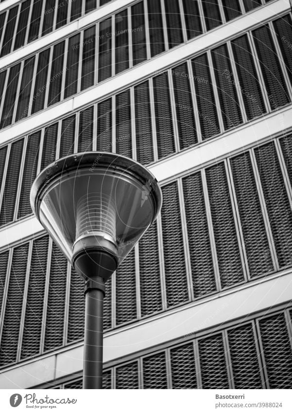 Moderne Straßenlaterne vor modernem Wohngebäude mit klappbarer Metallfassade als Schwarzweißaufnahme Gebäude Laterne Straßenbeleuchtung Beleuchtung grau Fassade