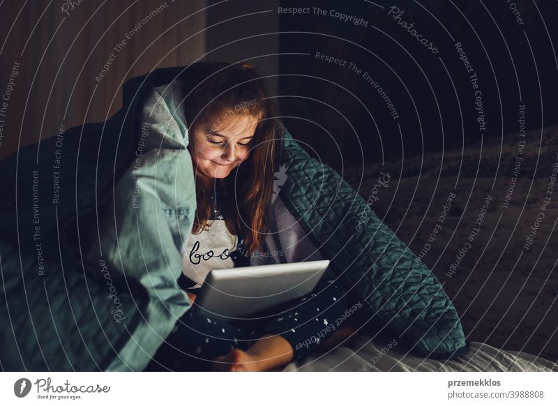 Kleines Mädchen mit Spaß beobachten, spielen und hören Geschichten auf Tablet-Computer liegen unter Bettdecke Nacht Schlafenszeit Kind heimwärts Schlafzimmer