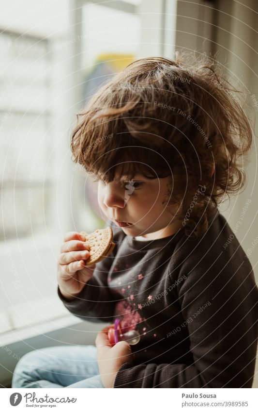 Nettes kleines Mädchen isst Keks Kind Kindheit Essen Denken Farbfoto Mensch lecker Freude authentisch Kaukasier Windstille Freizeit & Hobby 1-3 Jahre Glück