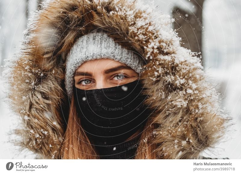 Schöne Frau mit Gesichtsmaske im Freien im Schnee attraktiv schön Schönheit Kaukasier abschließen kalt niedlich Schnee genießen Winter genießen Auge Mode Fell