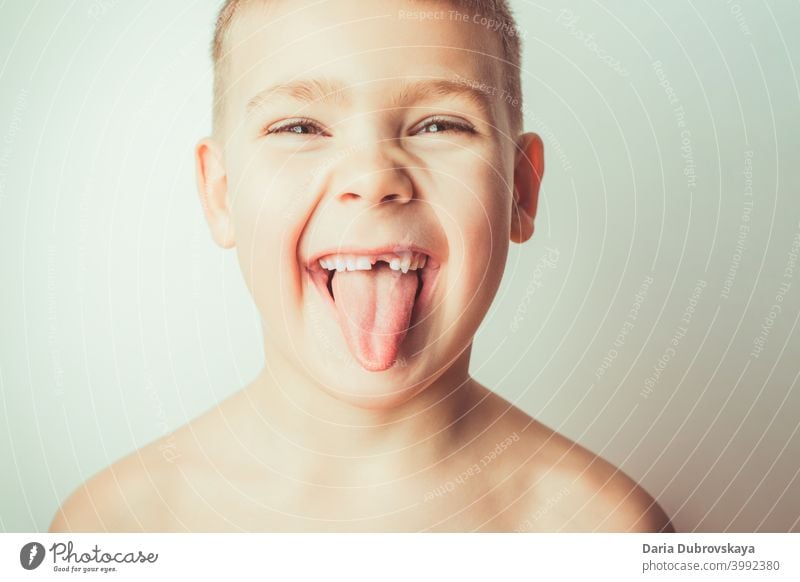 Lustiger Junge ohne Zahn zeigt Zunge wenig Kind Pflege männlich Person Hintergrund Mund Gesicht Porträt Kindheit lustig Zähne Fröhlichkeit weiß schön Lächeln