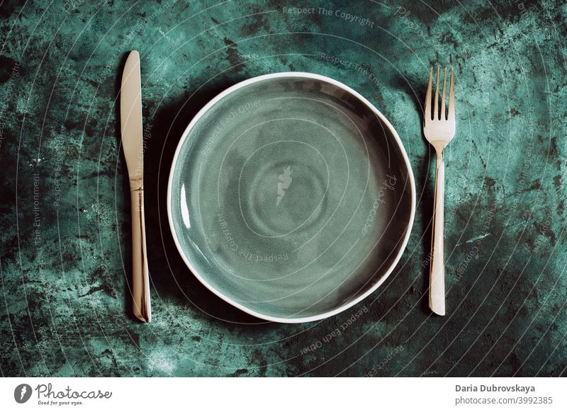 grüner Keramikteller auf grünem Hintergrund Dekor Ort Tisch Restaurant Speisekarte Abendessen Diät Besteck Kopie festlich Gabel leer Einstellung