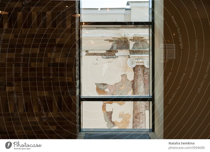 Blick aus dem Fenster eines modernen Gebäudes auf die baufällige Fassade eines Altbaus mit Säule. Architektur Kunst Hintergrund Baustein gebrochen Großstadt