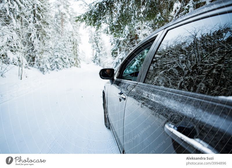 Auto bedeckt mit Schnee und Eis fahren auf der Winterstraße. Schöne Landschaft des Winters Wald und verschneite Landseite. Automobil Schneesturm PKW Weihnachten