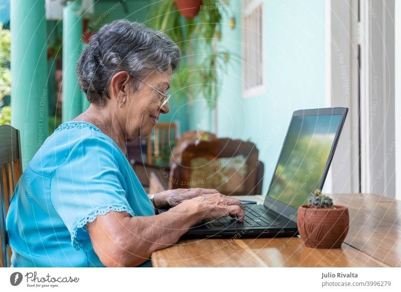 Ältere Frau bei der Arbeit mit einem modernen Laptop Sitzen Ruhestand Erwachsener Computer Technik & Technologie im Innenbereich alt Frauen Tippen Beteiligung