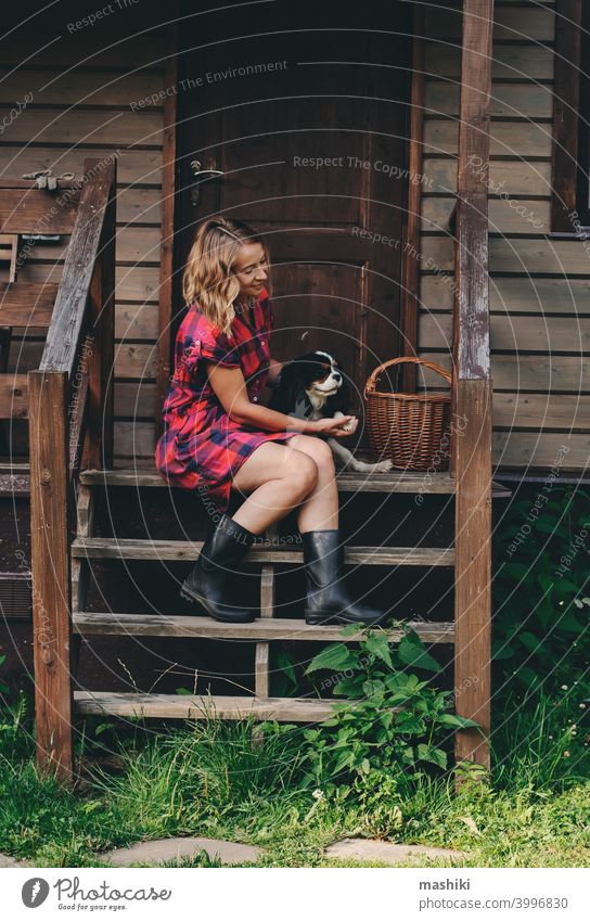 glückliche Frau sitzt auf der Veranda ihres hölzernen Landhauses. Ländliches Leben, weglaufen in die Natur, Ökologie Konzept Haus Sommer Glück Erwachsener