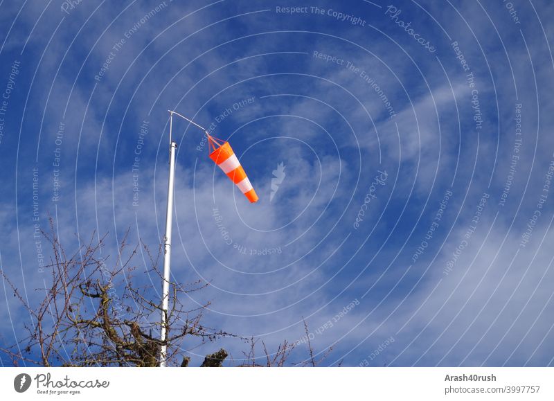 Wehender Windsack bei blauen Himmel Blau Wolken Natur Outside Orange-weiss Warnung Zeichen