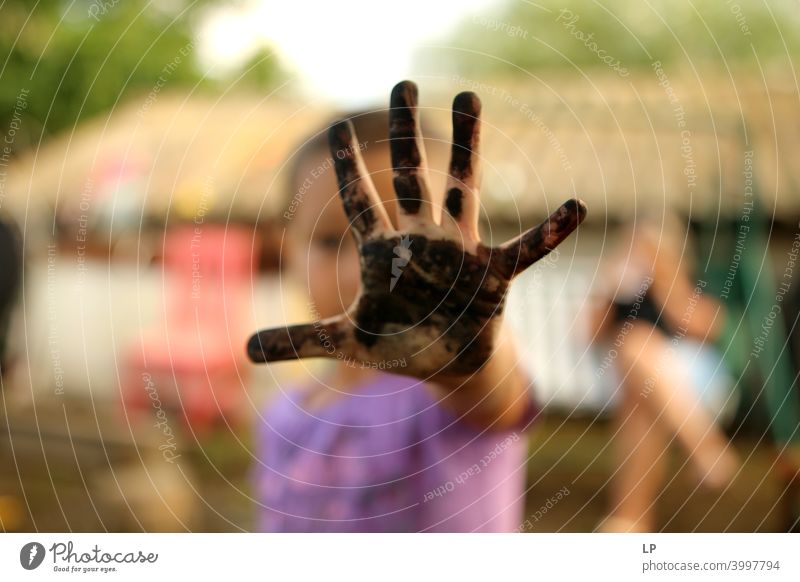 Kind zeigt eine bemalte schwarze Palme Vorderansicht Porträt Zentralperspektive Unschärfe Tag Detailaufnahme Nahaufnahme Muster unfreundlich Hautfarbe Finger