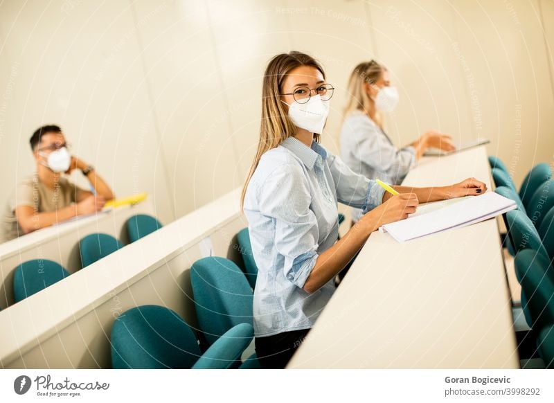 Weiblicher Student trägt medizinische Gesichtsschutzmaske zum Schutz vor Viren im Hörsaal Hochschule Bildung Frau jung Universität Virus Krankheit Coronavirus