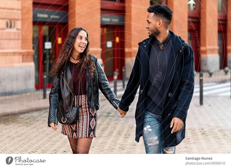 Interracial Paar hält sich an den Händen Straße die sich gegenseitig ansehen interrassisches Paar schwarz Afro-Look Afroamerikaner Vielfalt multirassisch