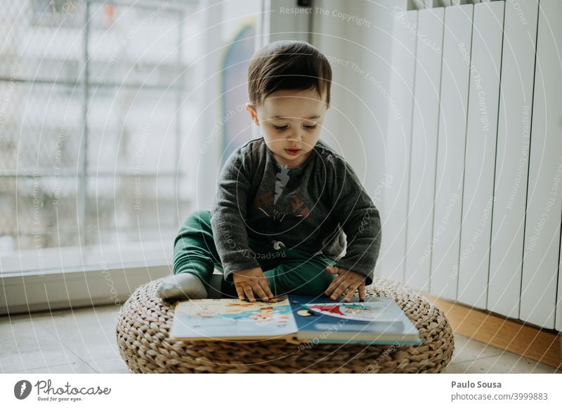 Kleinkind liest ein Buch zu Hause Kind Kindheit 0-12 Monate 1-3 Jahre Kaukasier lesen Bildung lehrreich Freude Glück niedlich Lifestyle Mensch Baby Tag Farbfoto