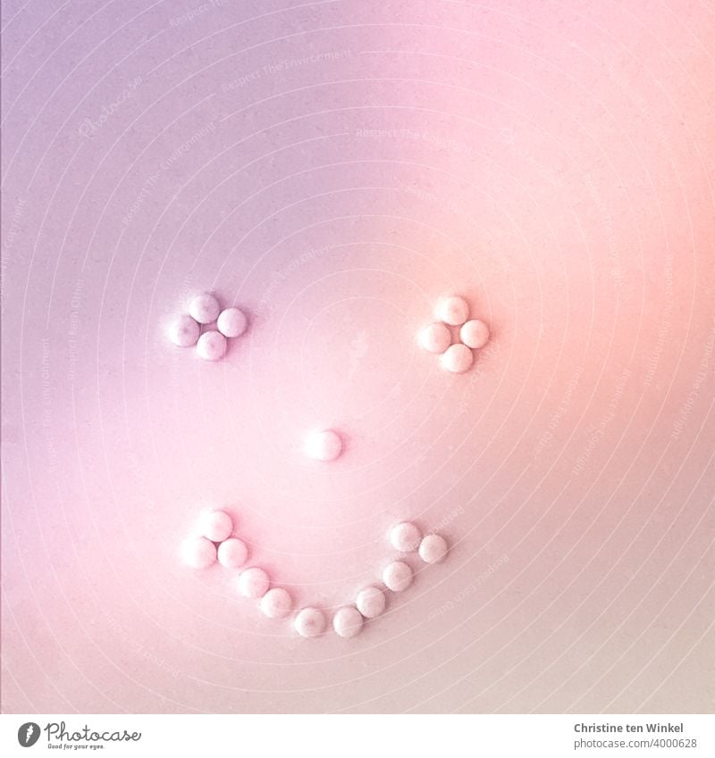 lächelndes Gesicht , gestaltet aus kleinen Magneten an einer Magnetwand, alles in Rosatönen Gesichtsausdruck Lächelndes Gesicht stilisiert freundlich grinsend