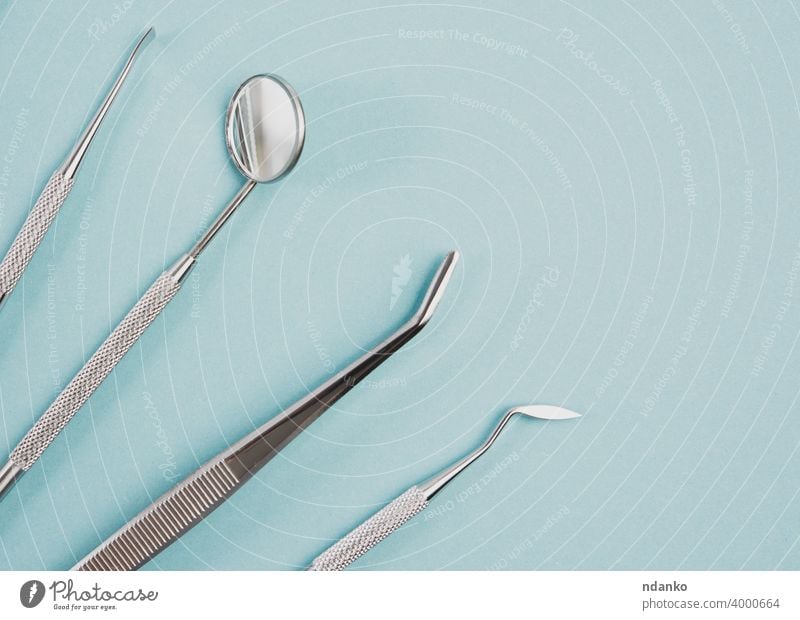 Metall medizinische Gegenstände des Zahnarztes auf blauem Hintergrund Zähne Schaber Gerät Pflege Spiegel Behandlung Klinik Medizin rostfrei Kulisse dental