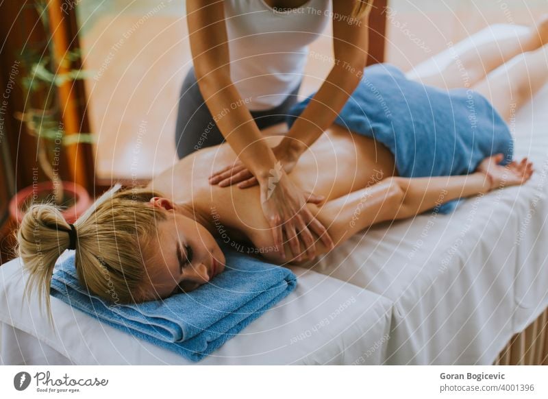 Schöne junge Frau liegend und mit Schulter-Massage in Spa-Salon während der Wintersaison Erwachsener schön Schönheit Körper Pflege Kaukasier Konzept