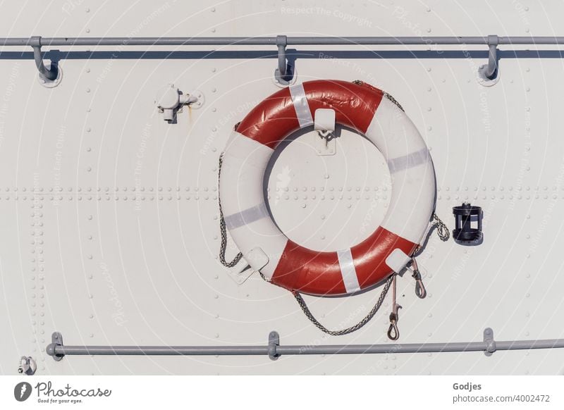 Rettungsring an metallener weißer Schiffswand Schifffahrt Farbfoto Außenaufnahme Menschenleer Sicherheit Wasser Meer Tag Wasserfahrzeug rot Bootsfahrt blau