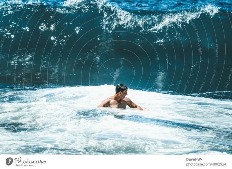 Riesige Welle im Anmarsch Meer Wellen groß Mann Wasser Gefahr Urlaub riesig hoch Ozean Risiko Wellengang bedrohlich