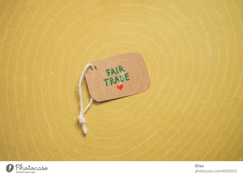 Etikett auf dem Fair Trade geschrieben steht auf gelbem Hintergrund. Konzept verantwortungsbewusster Konsum. fair fairer Handel sozial faire Bezahlung