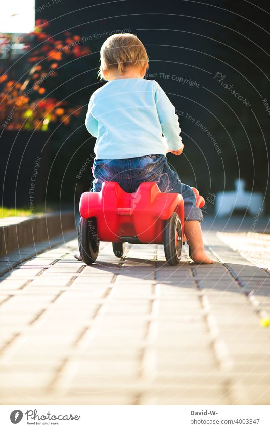 Kind unterwegs mit dem Bobby-Car Bobbycar freude draußen Kleinkind fahren Auto Kindheit Freude Sommer lernen