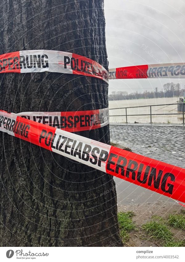 Polizeiabsperrung Tatort Hochwasser Absperrung Band flatterband Absperrband tat polizeigewalt polizeieinsatz Gefahr Rhein Fluss Baum Flussufer