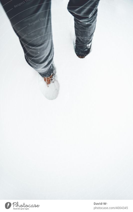 Mann steht im hohen Schnee hoch Schuhe Winter weiß spazieren Wintereinbruch Schneedecke kalt wandern Winterstimmung