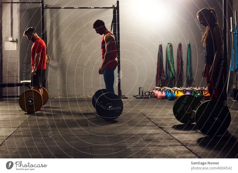 Drei Erwachsene, die bereit sind, Hanteln zu heben. Crossfit Funktionstraining Fitnessstudio Gesundheit Sport Training Übung Lifestyle Erwachsener Menschen Raum