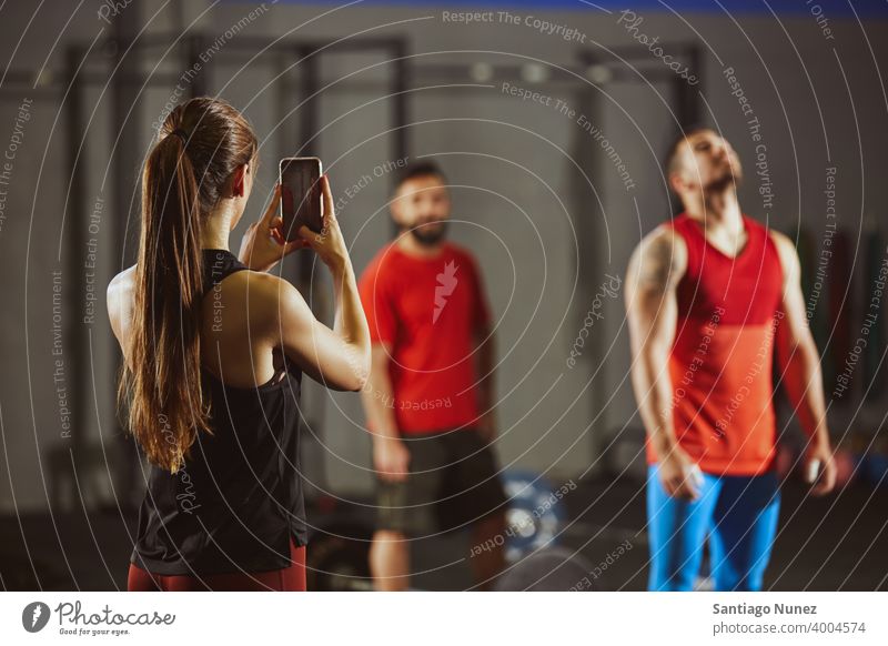 Frau, die ein Foto mit Smartphone im Fitnessstudio macht. Crossfit Funktionstraining Gesundheit Sport Training Übung Lifestyle passen Erwachsener