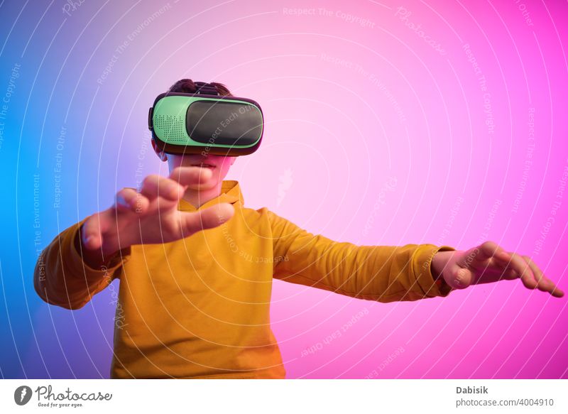 Junge mit Virtual-Reality-Brille auf buntem Hintergrund. Zukunftstechnologie, VR-Konzept Headset virtuell Realität Schutzhelm Technik & Technologie Gerät Spiel