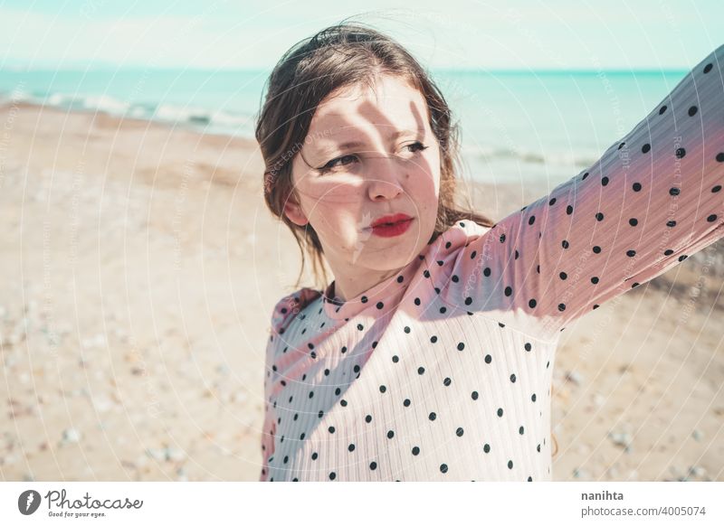Junge Frau trägt ein rosa Kleid am Strand Feiertage trendy kawaii lässig Lifestyle Leben blond natürlich Schönheit attraktiv hübsch Mode Model Wind windig MEER