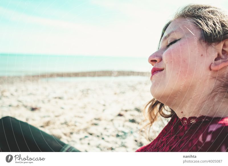 Junge und trendige Frau in einem sonnigen Tag sitzen am Strand trendy attraktiv Spitze Model Sand Hintergrundbeleuchtung rot blond Sonne sexy jung Jugend