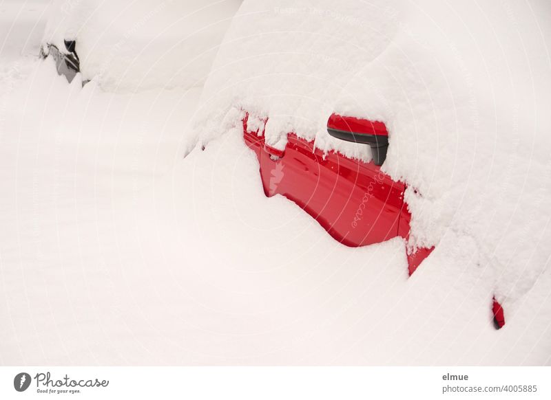 Schneemassen liegen auf einem roten und einem schwarzen Auto, so dass nur noch wenig von diesen zu sehen ist / eingeschneit / Wintereinbruch / Neuschnee