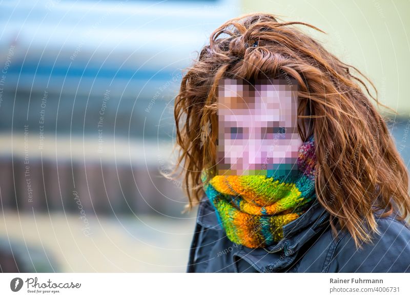 Porträt einer Frau mit anonymisierten Gesicht, sie hat rote Haare, der Hintergrund ist unscharf Gesichtserkennung Protest rothaarig Beobachtung Urheberrecht