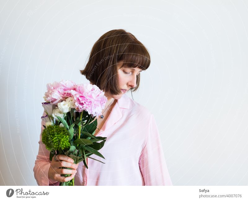 Junge Frau hält schöne Pastell Pfingstrose Bouquet Mutter Tag Blumenhändler Muttertag Frühling Gesicht rosa Lifestyle Frauentag Blumenstrauß Lächeln Ausdruck